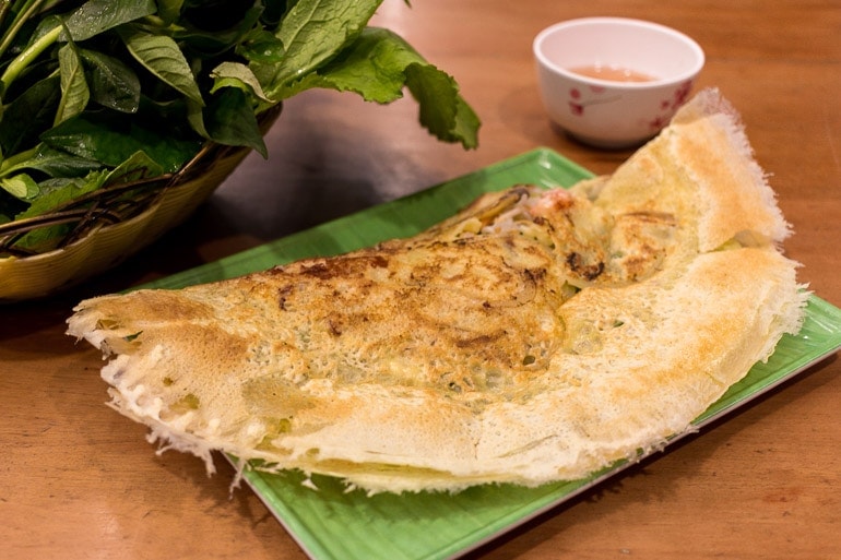 typical Vietnamese food the bahn xeo looks like a crepe made with rice flour and turmeric filled with pork meat, shrimps, and bean sprouts