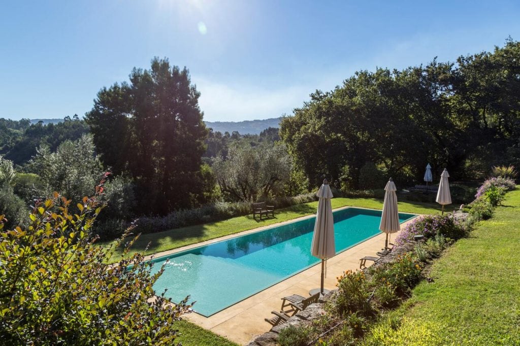 A piscina no quintal rodeado de árvores do Hotel Vinícola Quinta do Ameal em Portugal