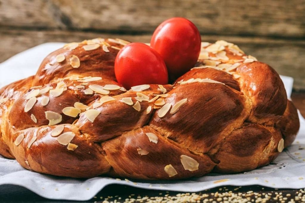 greek tsoureki braided bread with red painted eggs on top