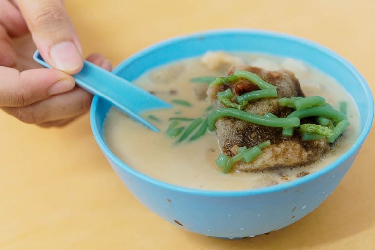 uma tigela azul com cendol and raspadinha de gelo sobremesa típica da Malásia