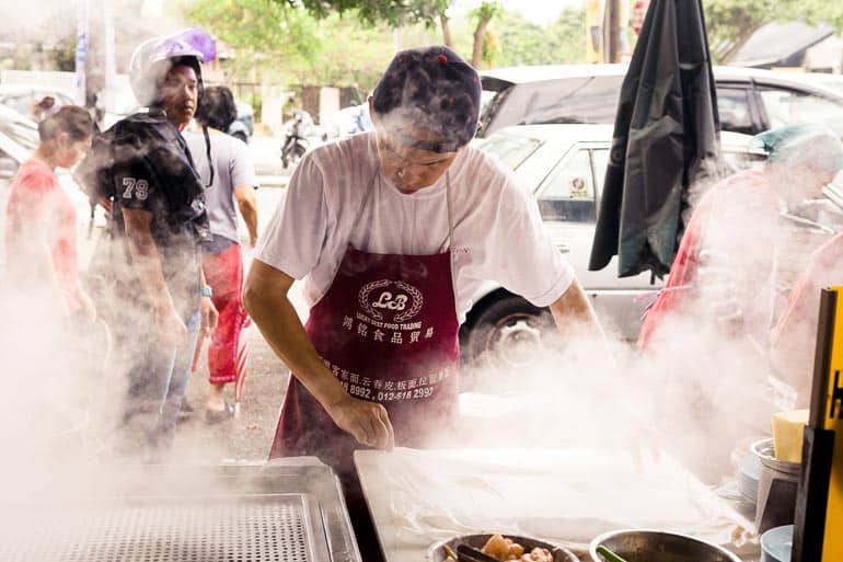 Vendedor de comida de rua preparando prato quente em Ipoh