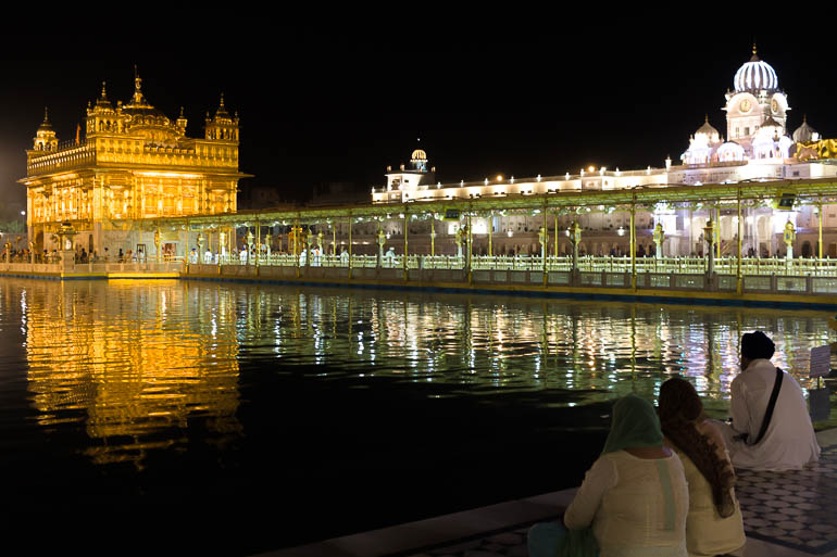 people looking at the golden temple lights during the night