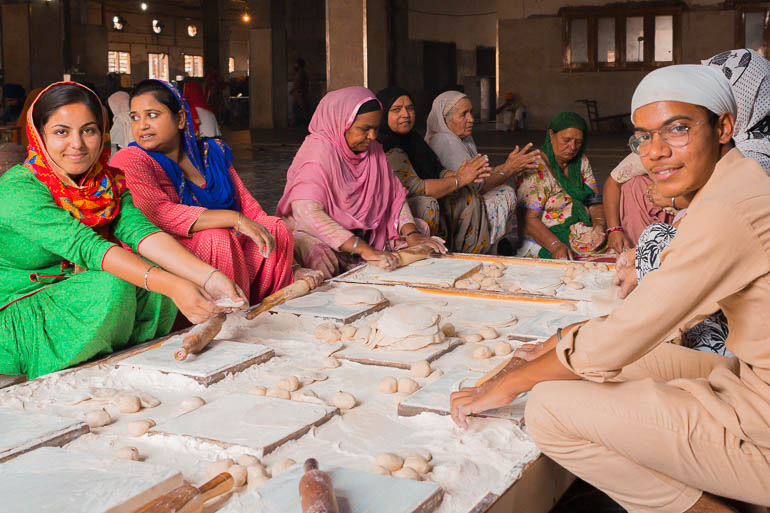 as pessoas ajudando a fazer pão na cozinha do Templo Dourado em Amritsar
