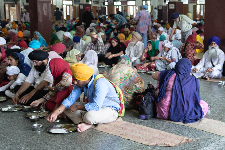 Pessoas comendo no Templo Dourado de Amritsar