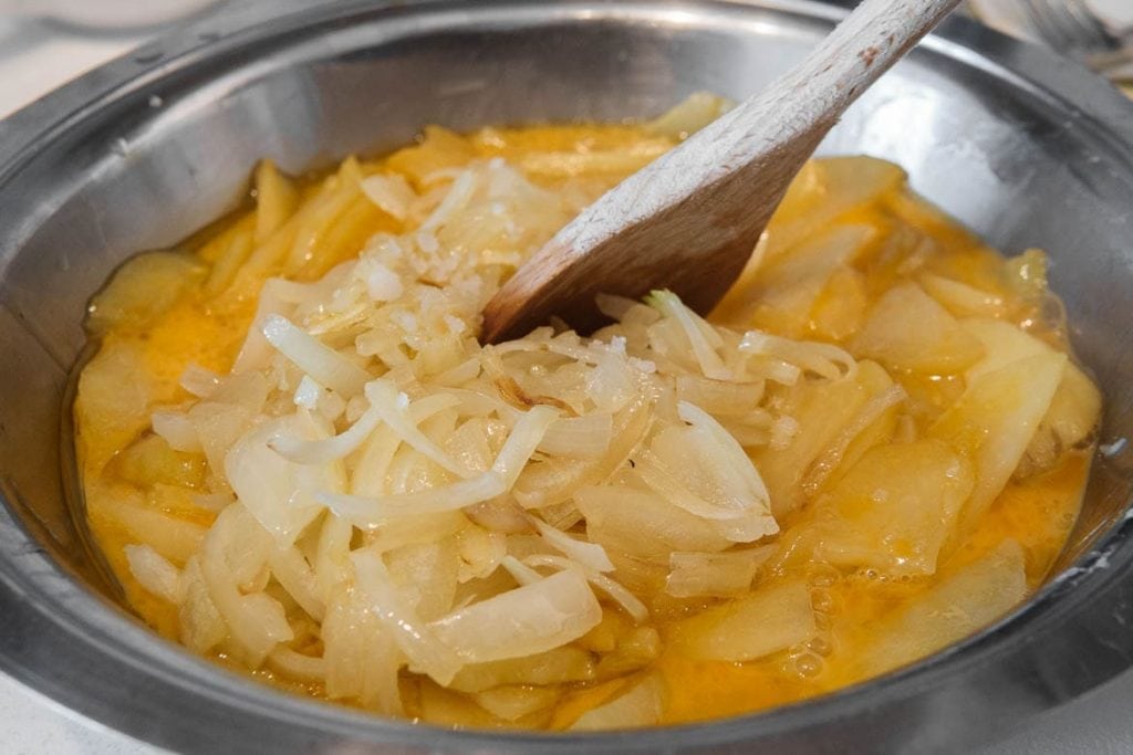 recipe spanish tortilla mixing the ingredients eggs with onion and potatoes