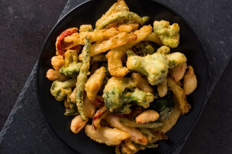 A bowl with vegetable tempura is a traditional snack from Portugal and popularized by Japan