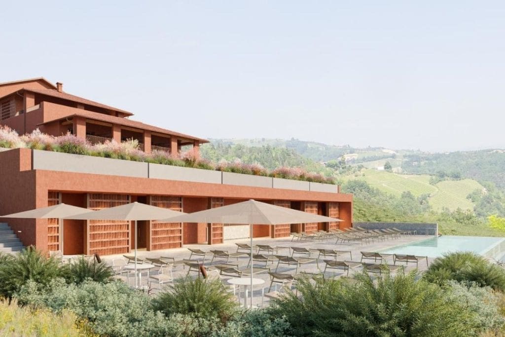 vista do edifício do Hotel Vínico Casa Langa com piscina e cercado por vinhedos no Piemonte, Itália