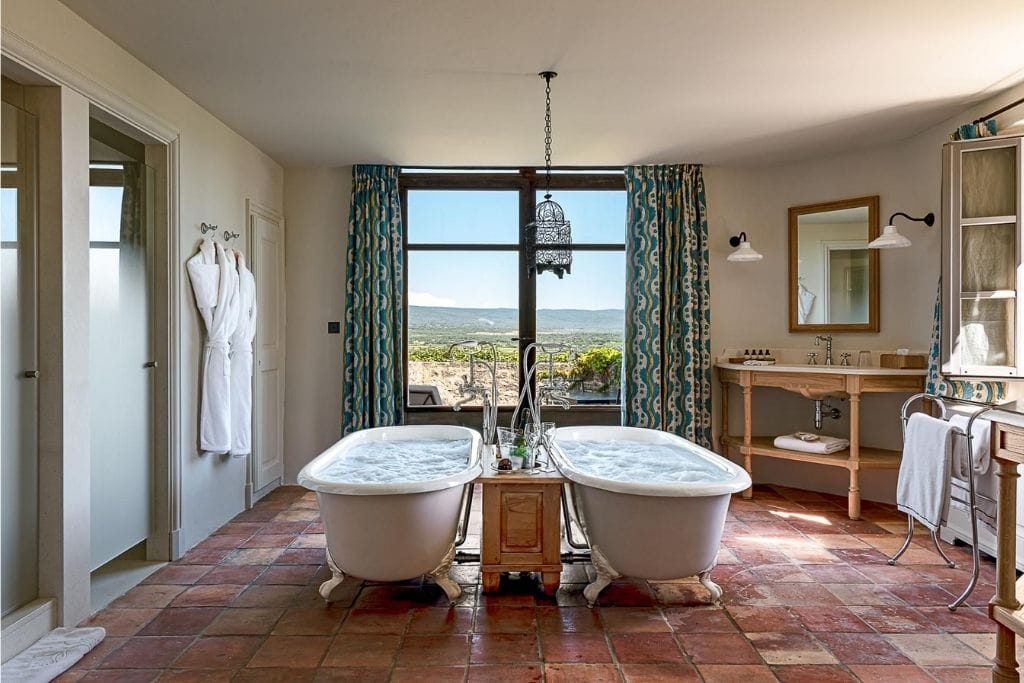 vista do elegante banheiro com duas banheiras que da vista para os vinhedos do hotel vinícola Crillon le Brave na França, região da Provença