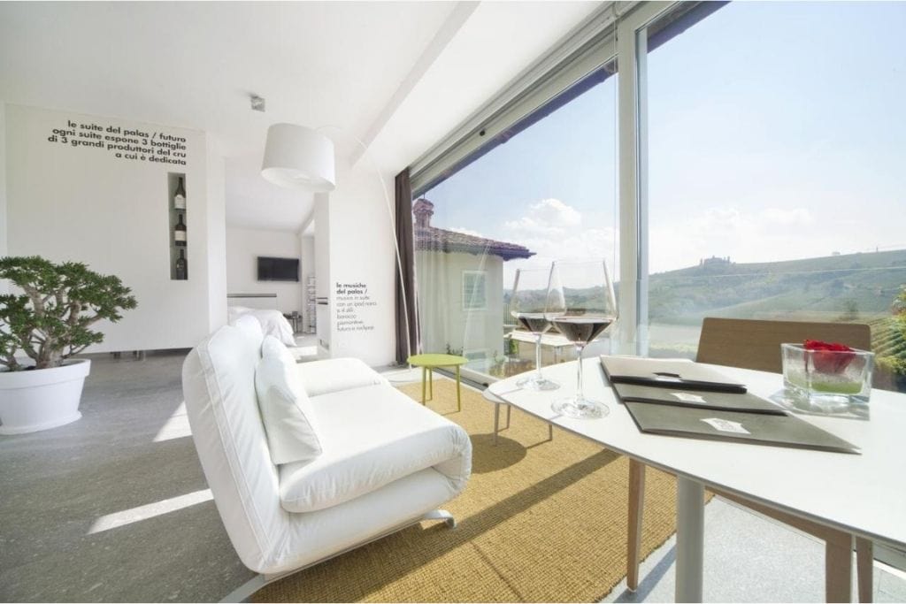 the interior room with white sofa with a view of the vineyards of the piedmont winery hotel Palas Cerequio in Italy