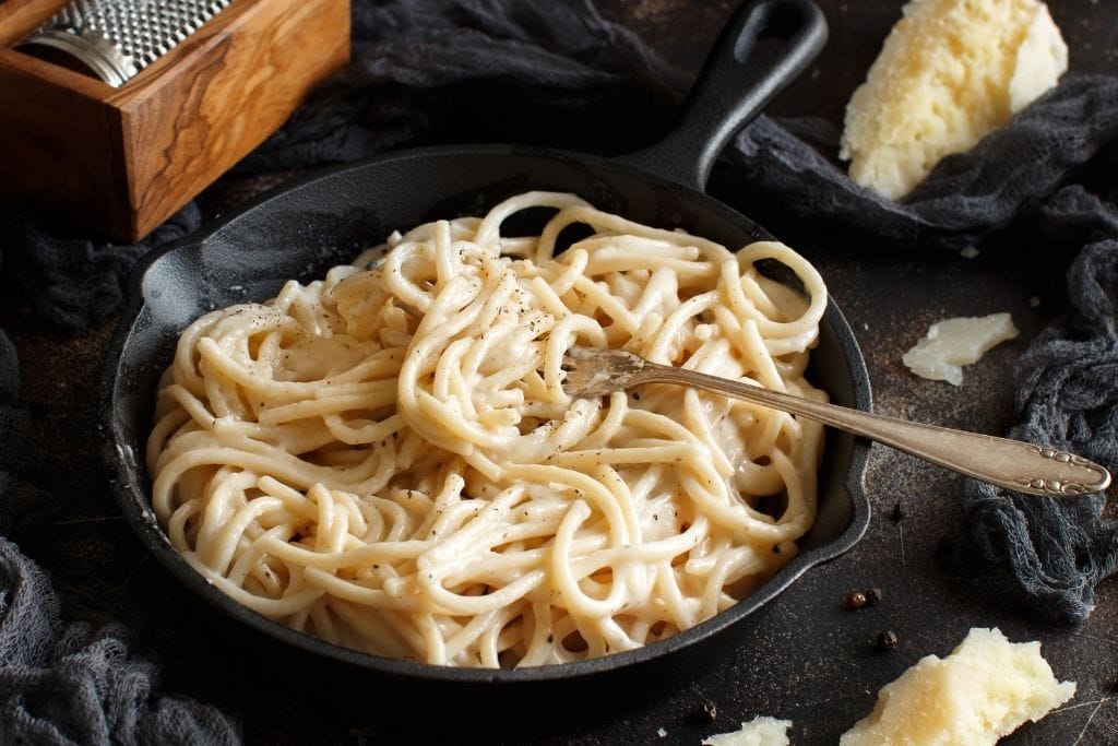 cacio e pepe on a plate served only with cheese and black pepper, very traditional roman food